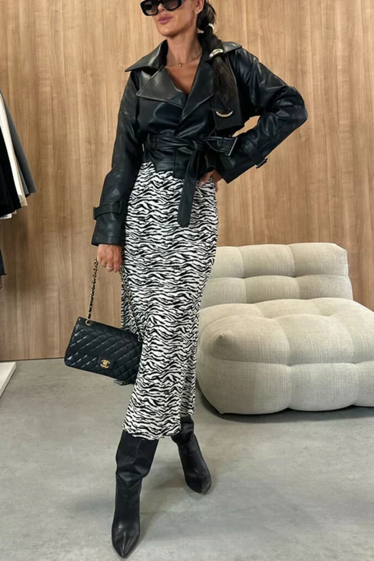 Woman wearing snakeskin print midi skirt with black top.