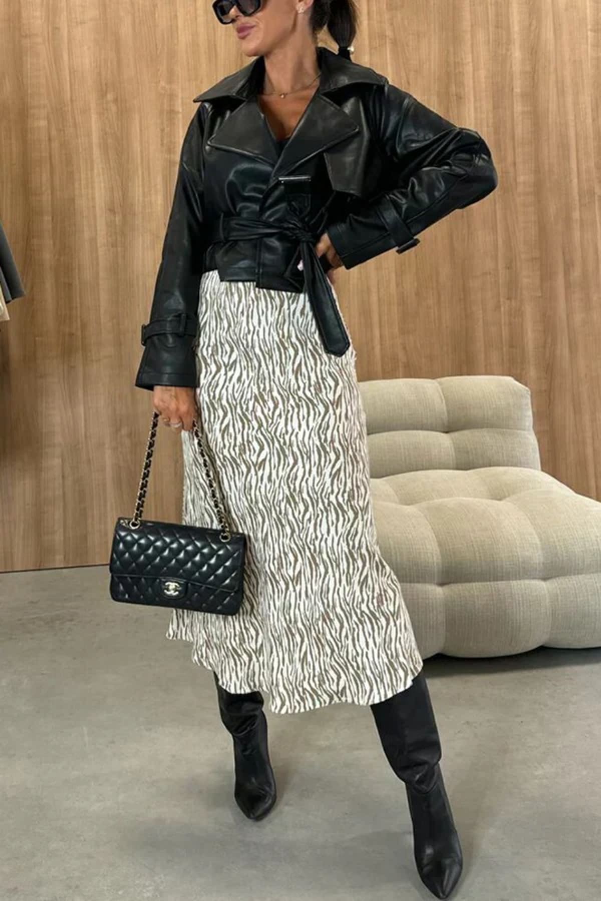 Woman wearing snakeskin print midi skirt with black top.