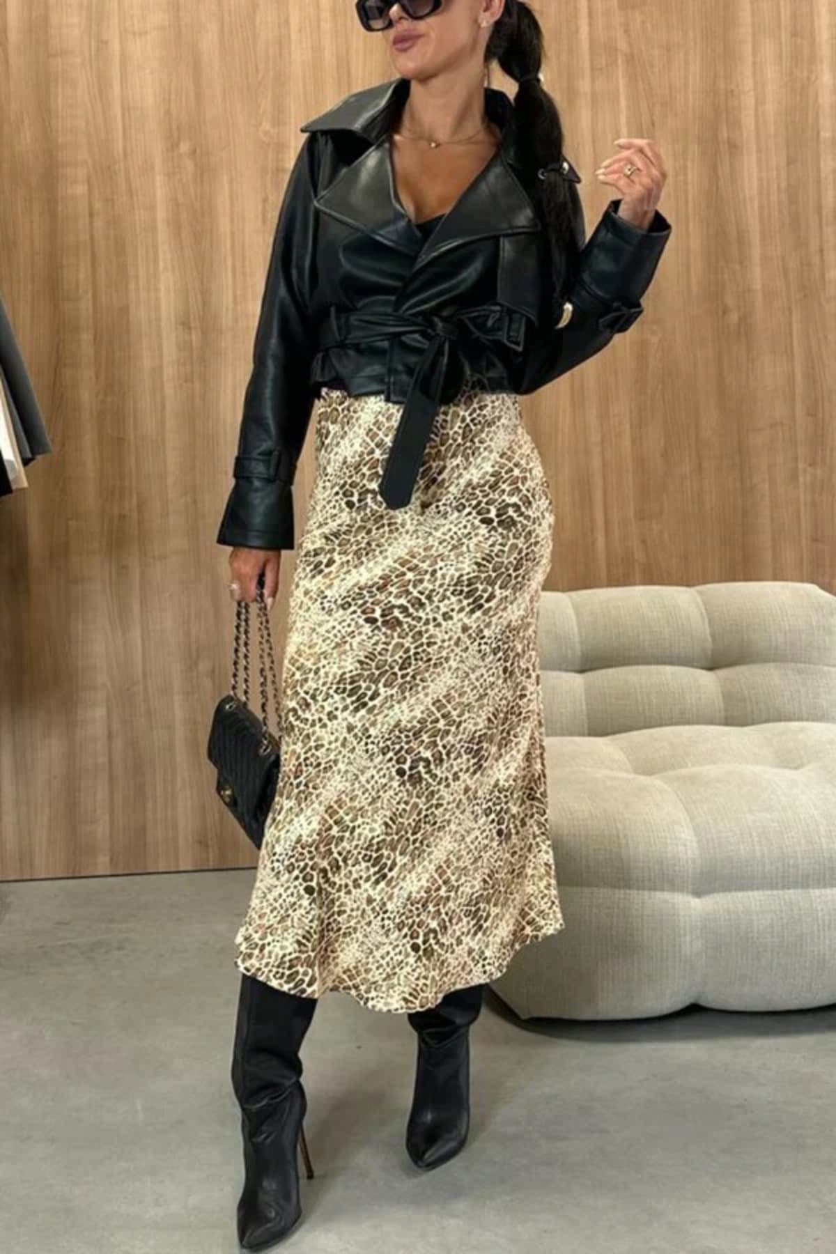 Woman wearing snakeskin print midi skirt with black top.