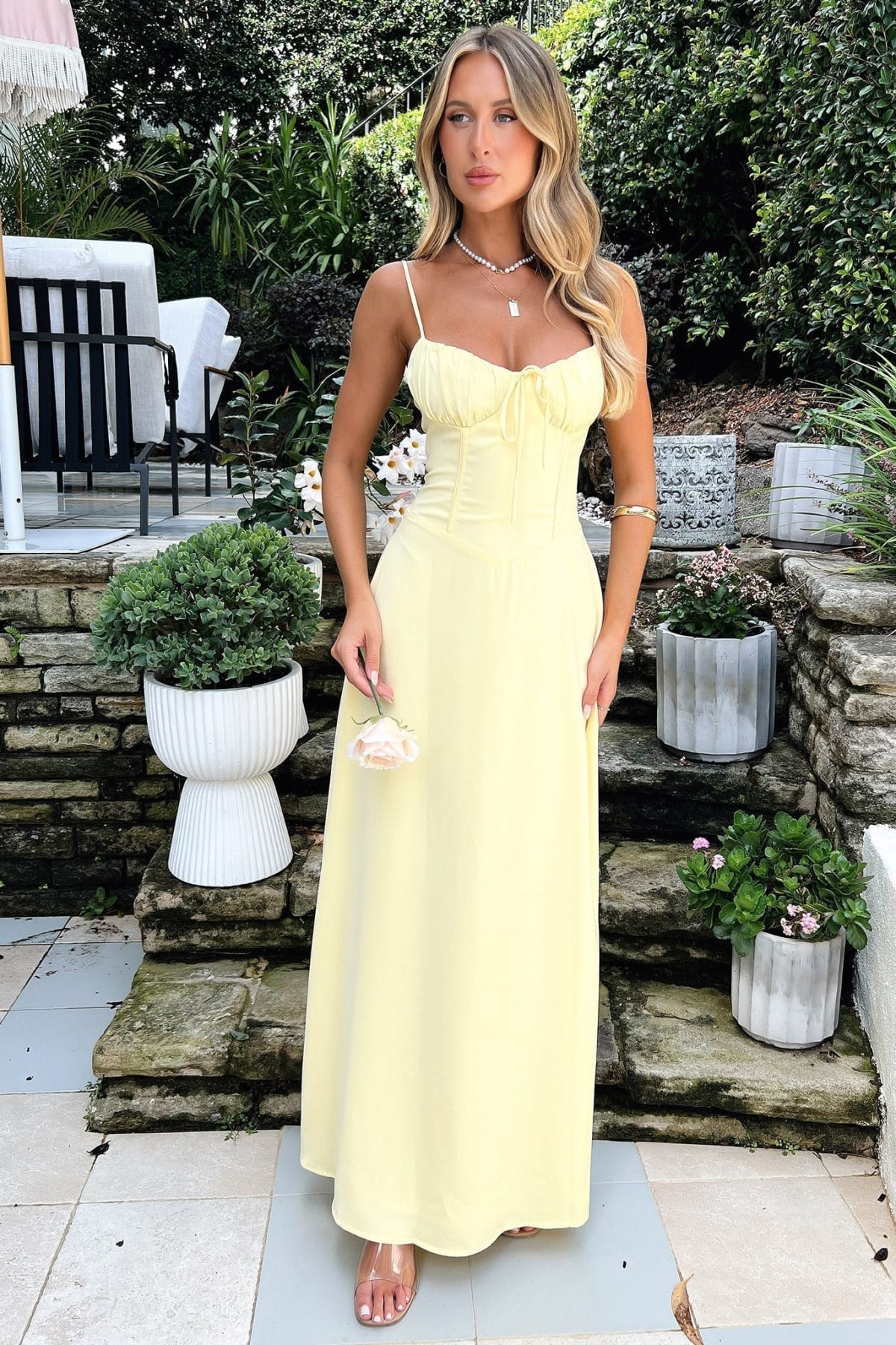 Woman wearing a maxi dress with spaghetti straps and wrap design.