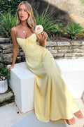 Woman wearing a maxi dress with spaghetti straps and wrap design.