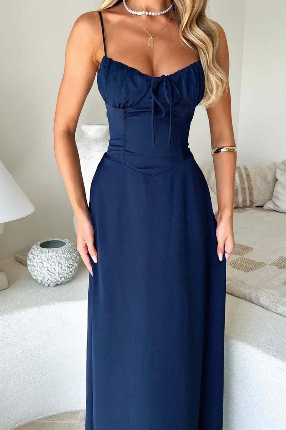 Woman wearing a maxi dress with spaghetti straps and wrap design.