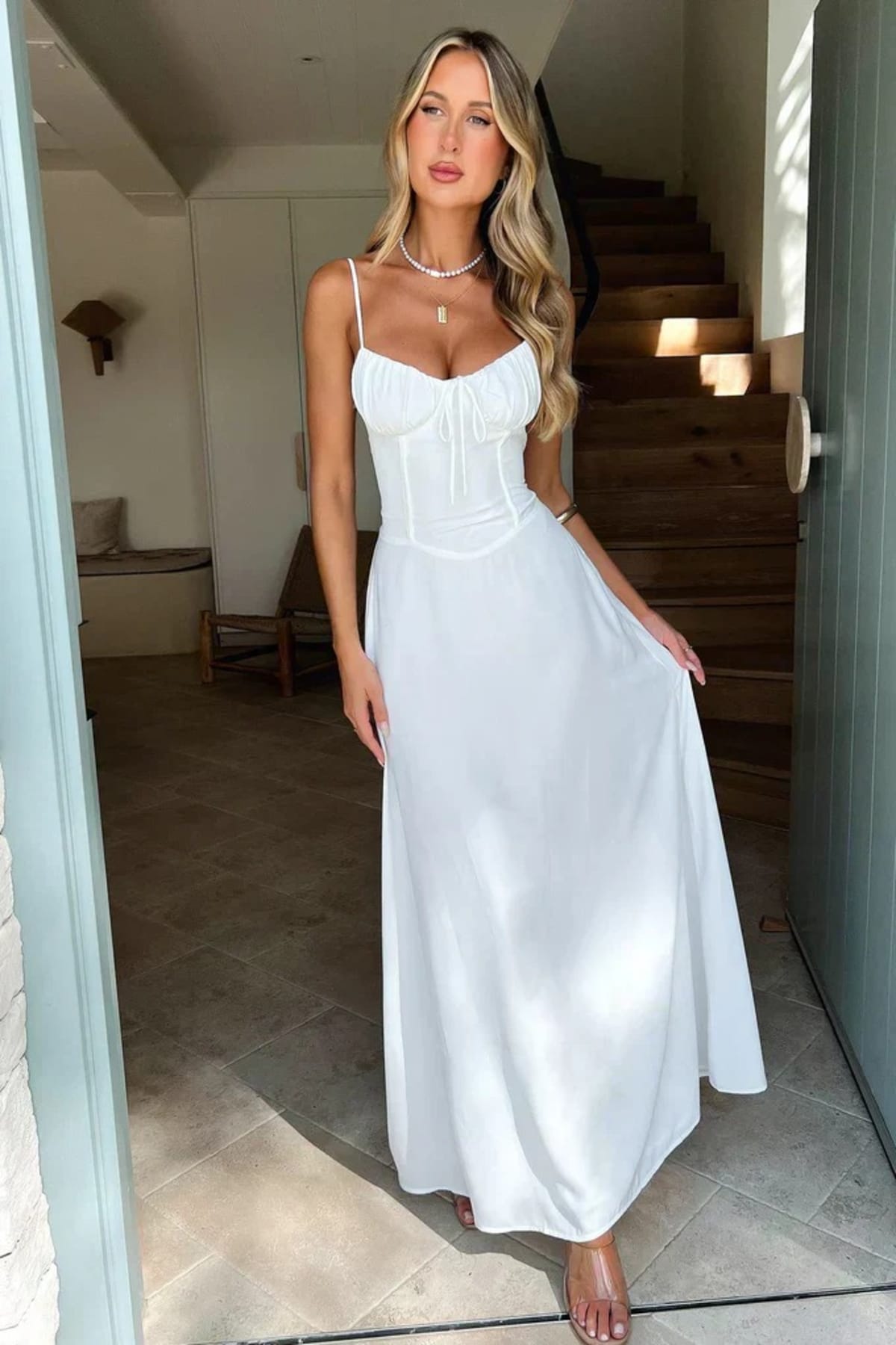 Woman wearing a maxi dress with spaghetti straps and wrap design.
