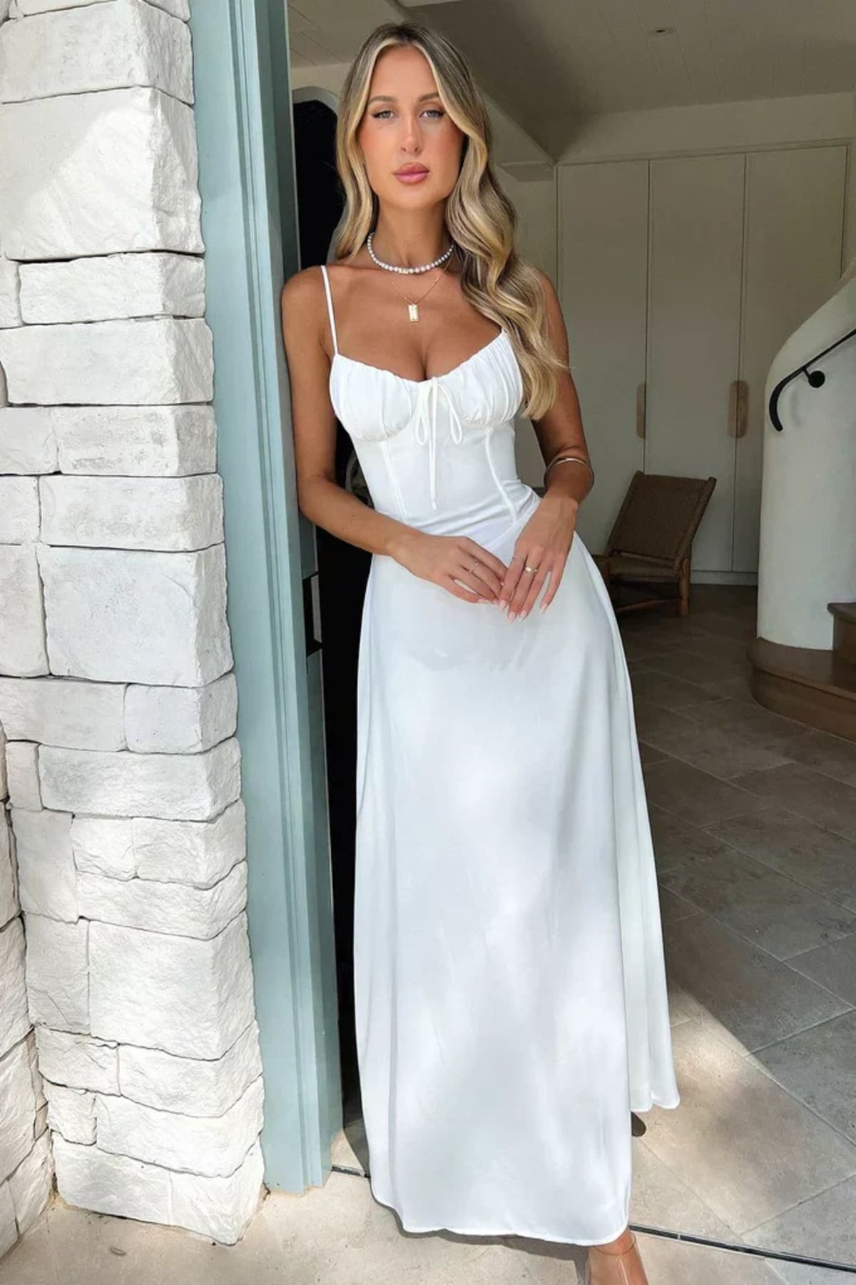 Woman wearing a maxi dress with spaghetti straps and wrap design.