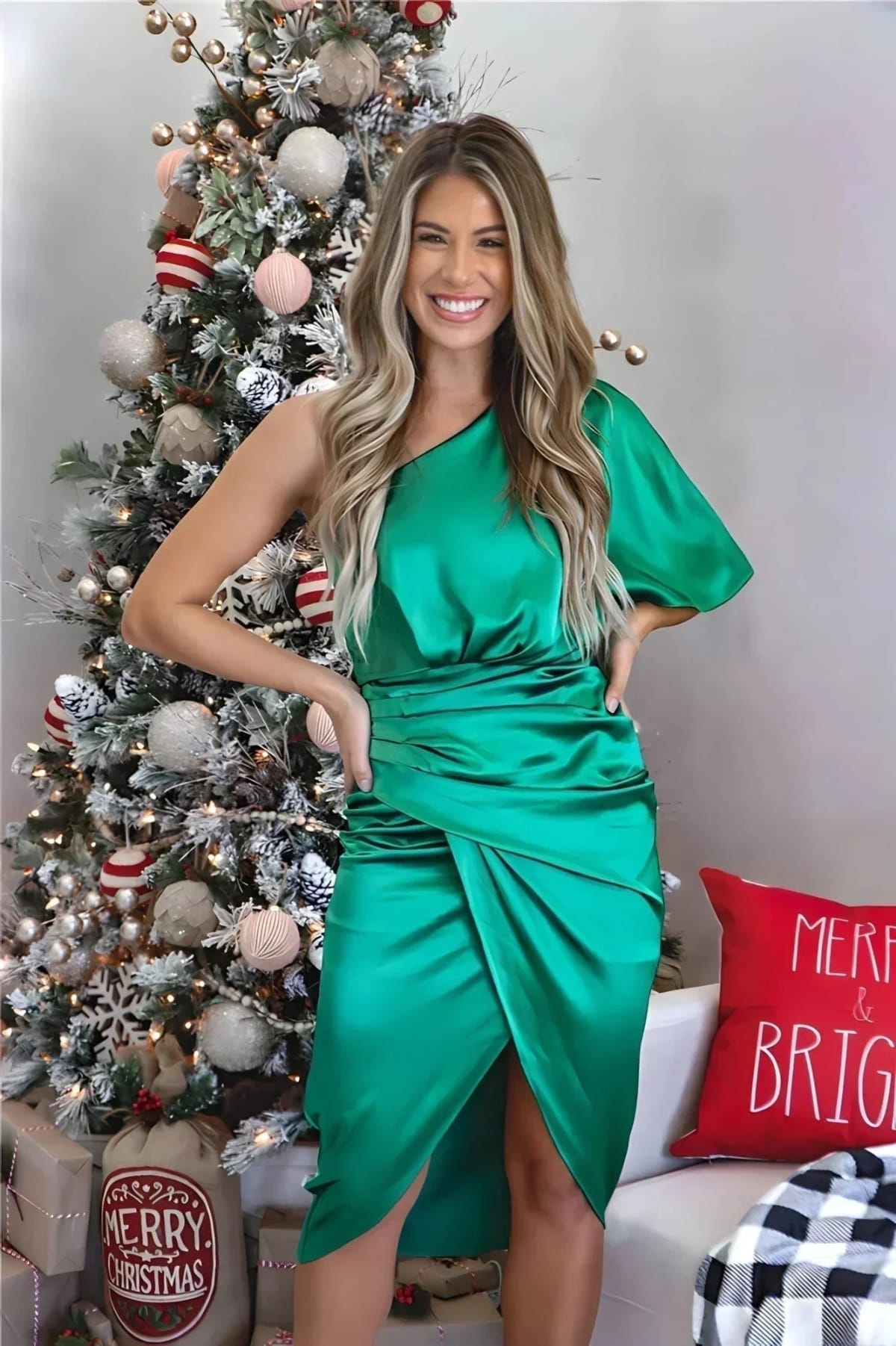 Woman in a one-shoulder black midi dress with draped bodice and ruched wrap skirt.