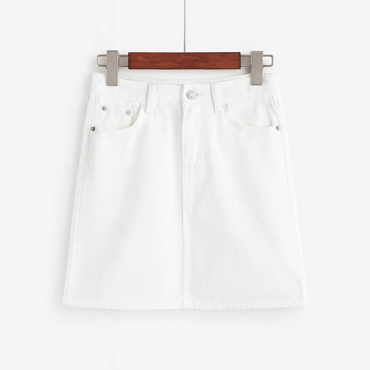 White denim mini skirt with A-line silhouette on hanger.