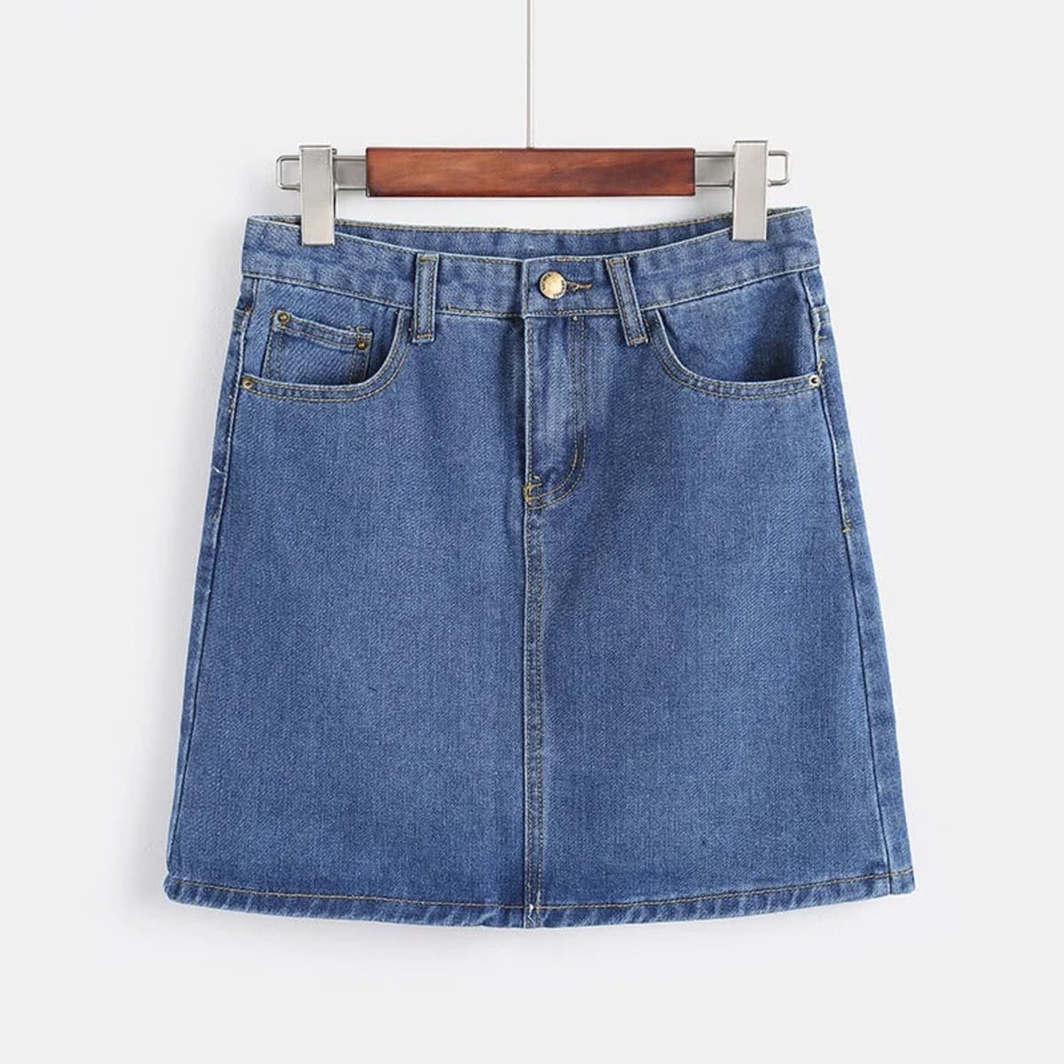White denim mini skirt with A-line silhouette on hanger.