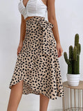 Woman in a wrap midi skirt with asymmetrical hem and tie-waist.