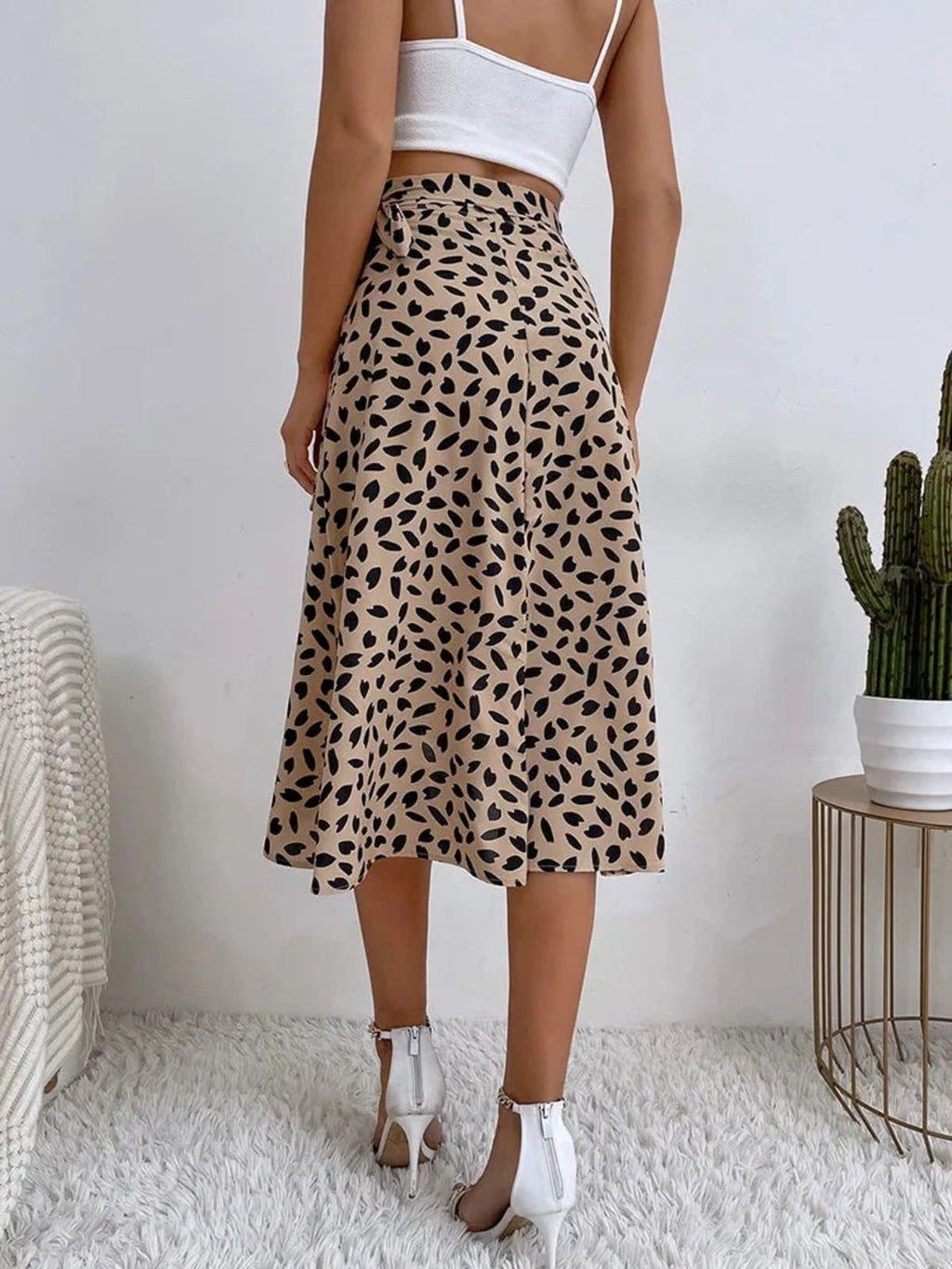 Woman in a wrap midi skirt with asymmetrical hem and tie-waist.