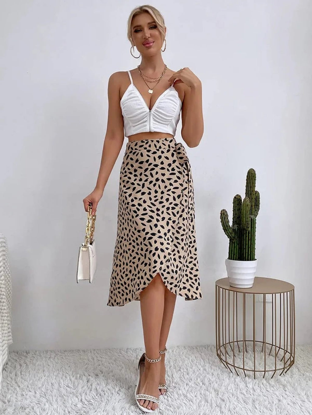 Woman in a wrap midi skirt with asymmetrical hem and tie-waist.