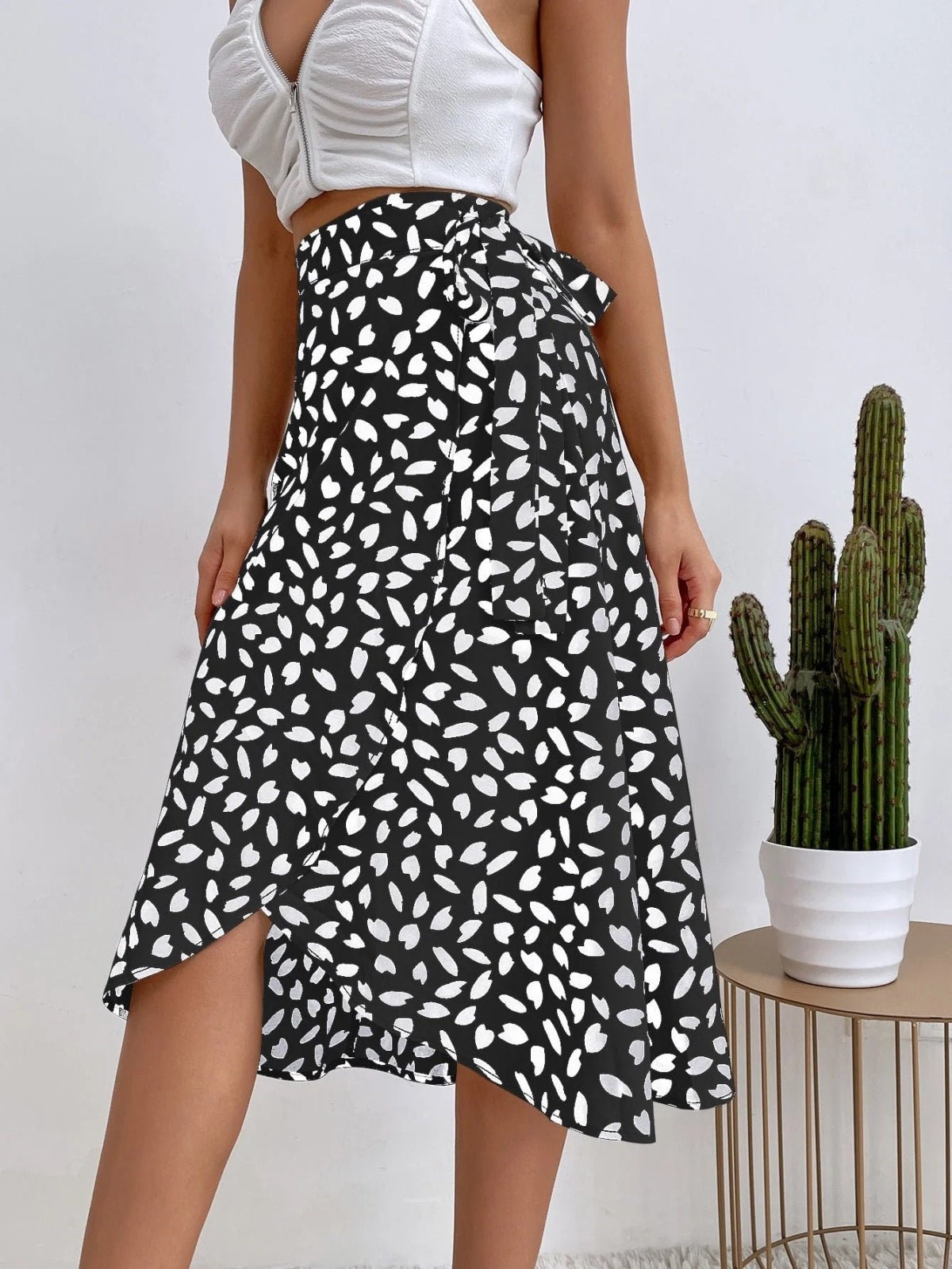Woman in a wrap midi skirt with asymmetrical hem and tie-waist.