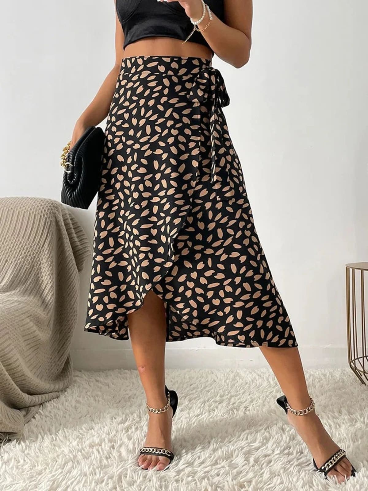 Woman in a wrap midi skirt with asymmetrical hem and tie-waist.