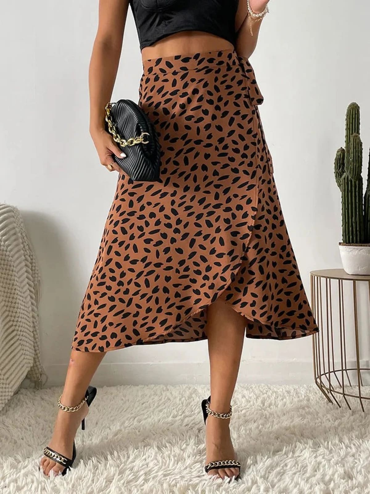 Woman in a wrap midi skirt with asymmetrical hem and tie-waist.