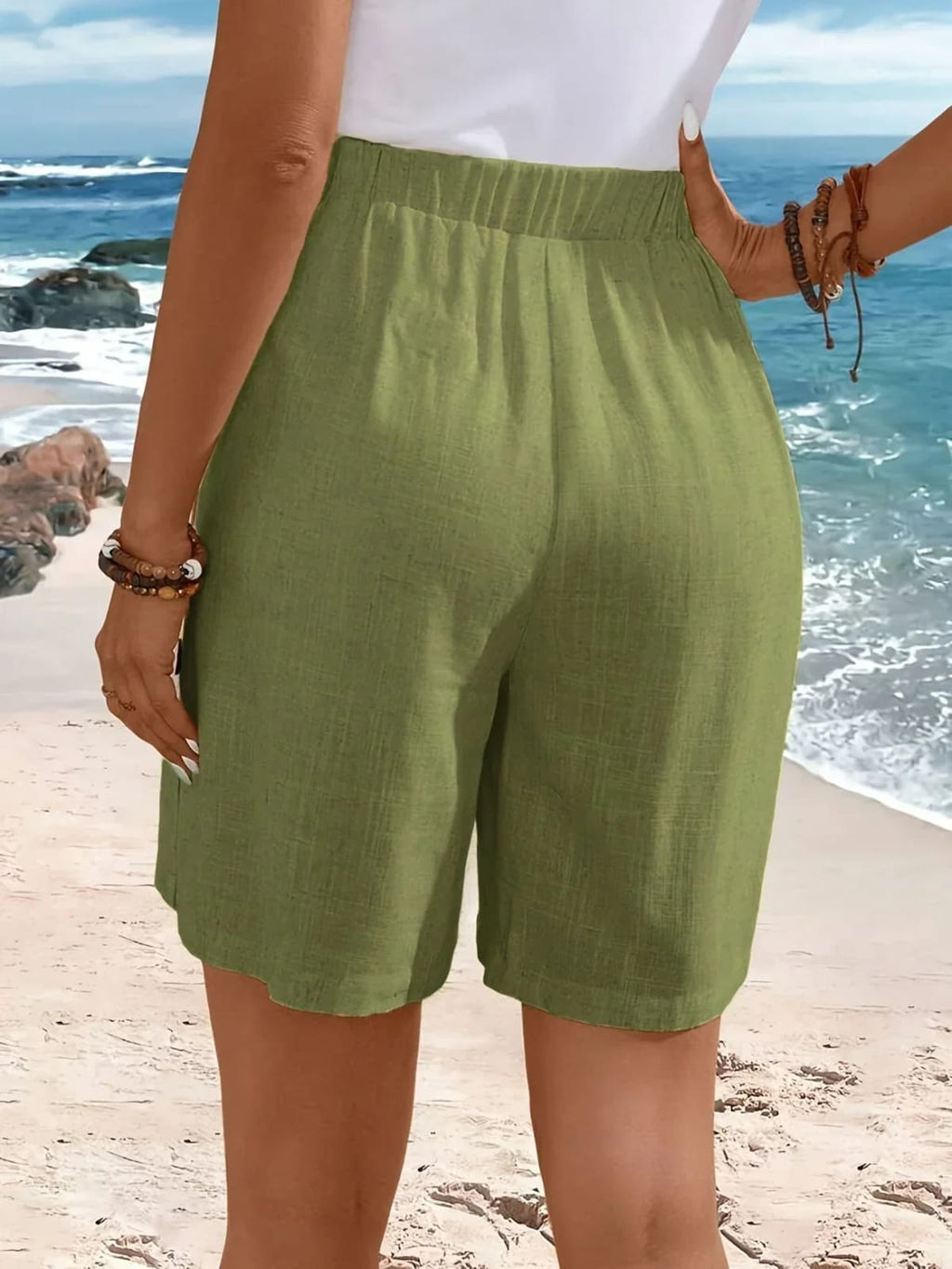 Mid-thigh shorts with side buttons and elastic waist.