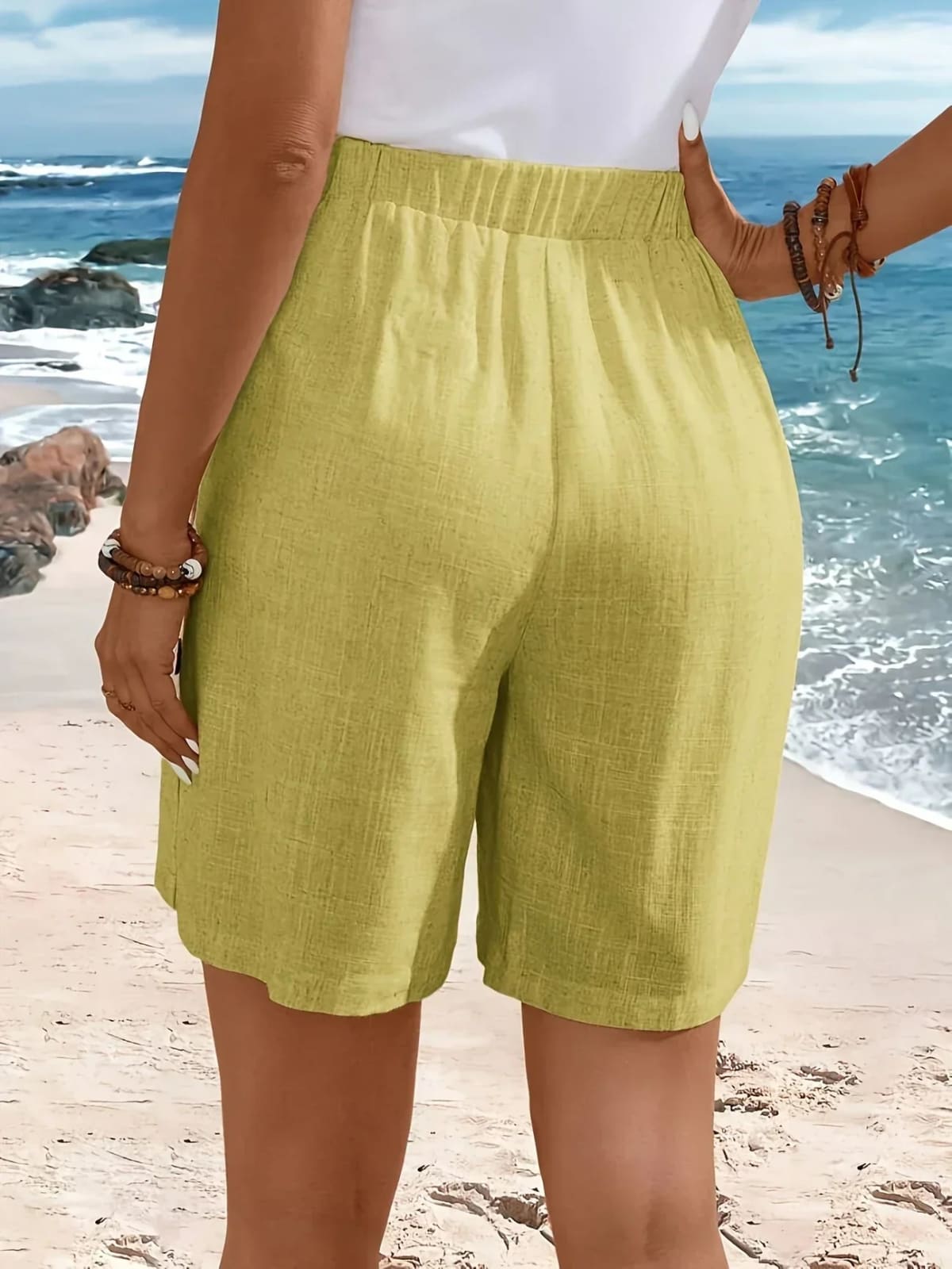 Mid-thigh shorts with side buttons and elastic waist.
