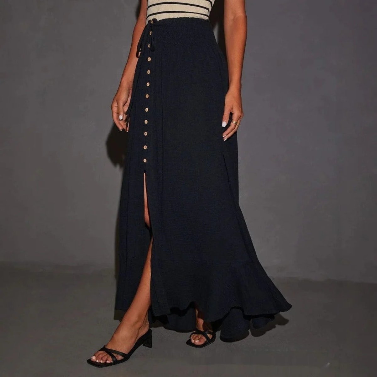 Woman wearing high-waisted button-front maxi skirt with drawstring waist.