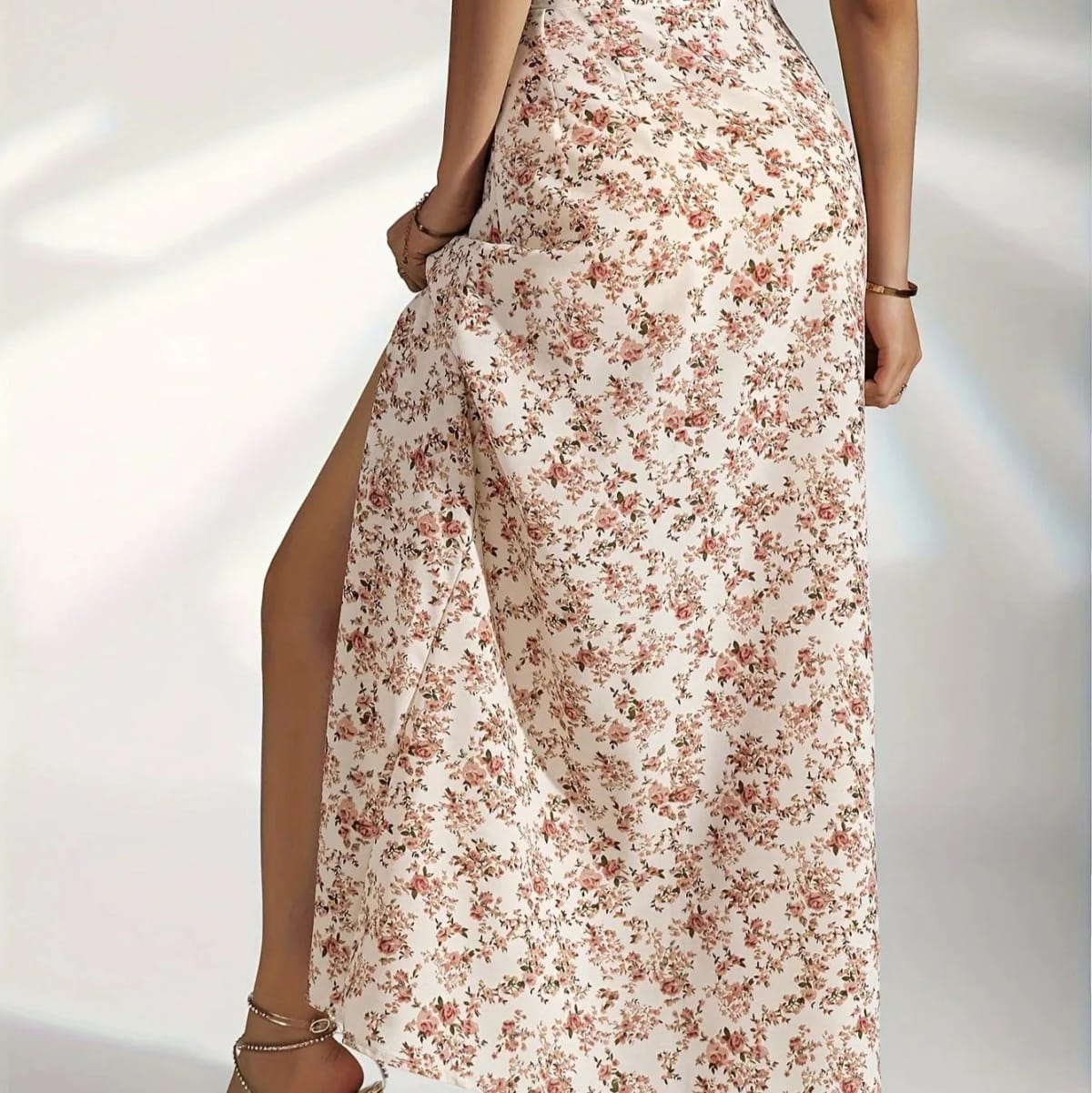 Woman wearing a floral maxi skirt with a side slit.