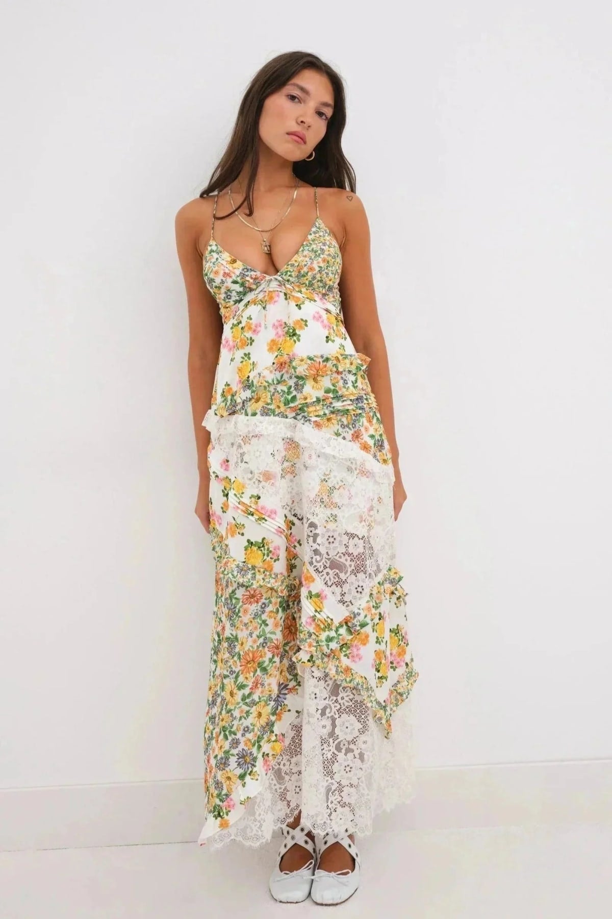 Woman wearing a floral and lace patchwork maxi dress with ruffles.