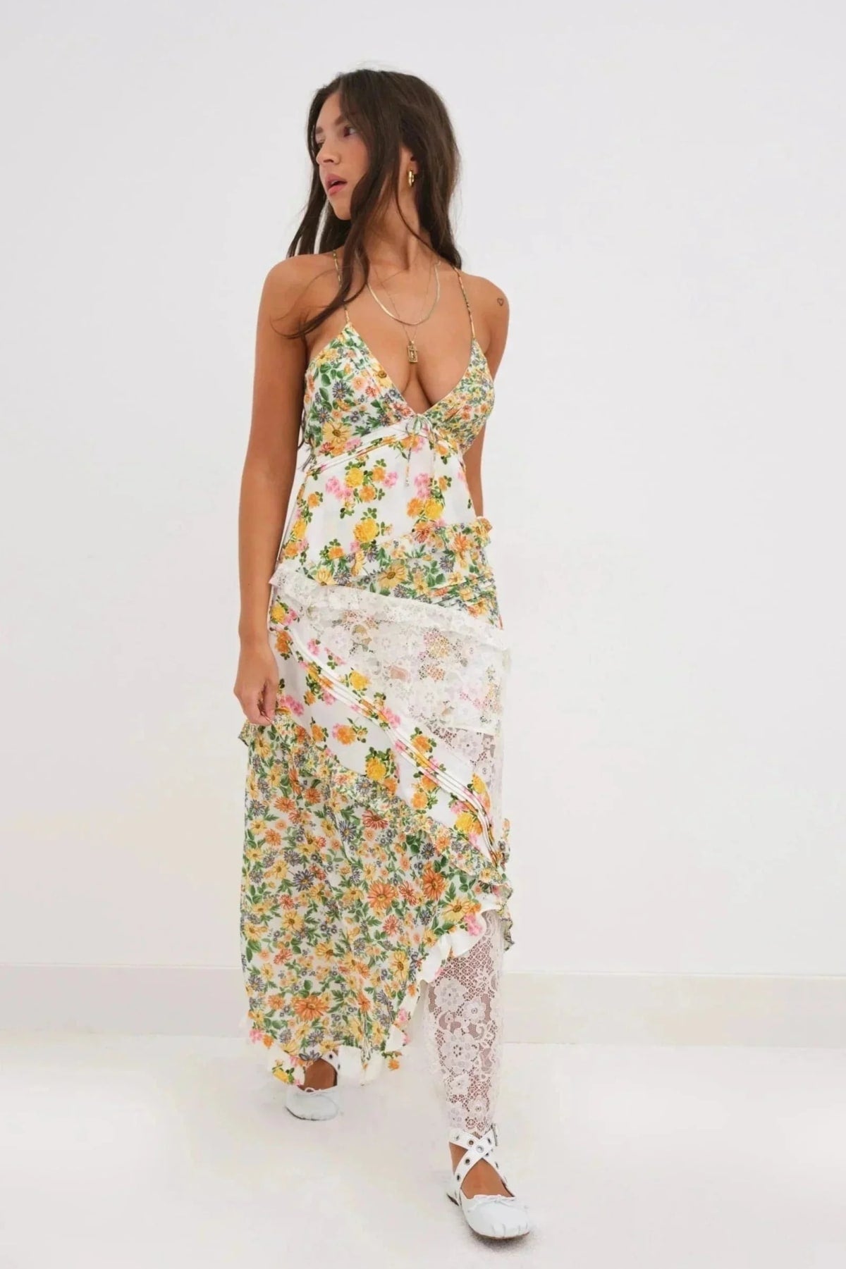 Woman wearing a floral and lace patchwork maxi dress with ruffles.