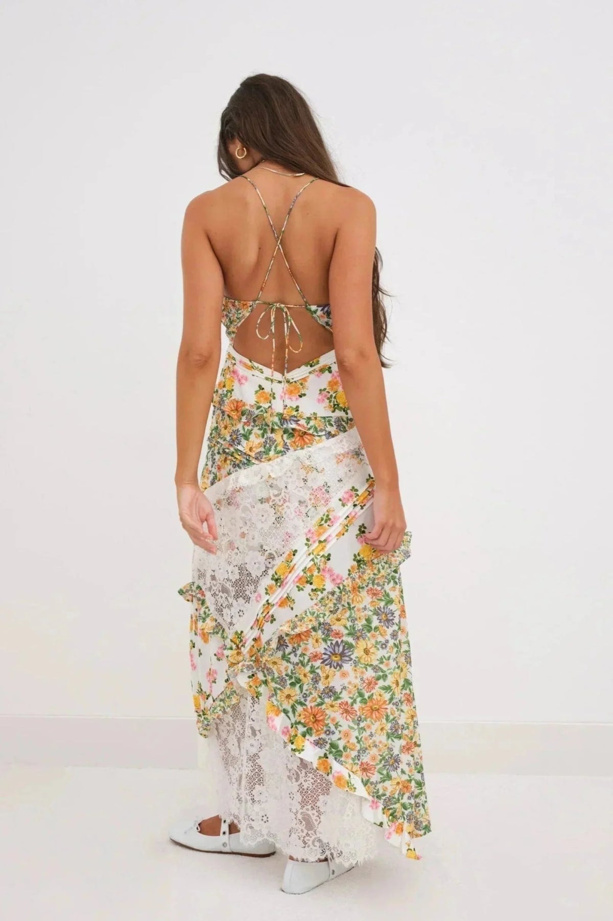 Woman wearing a floral and lace patchwork maxi dress with ruffles.