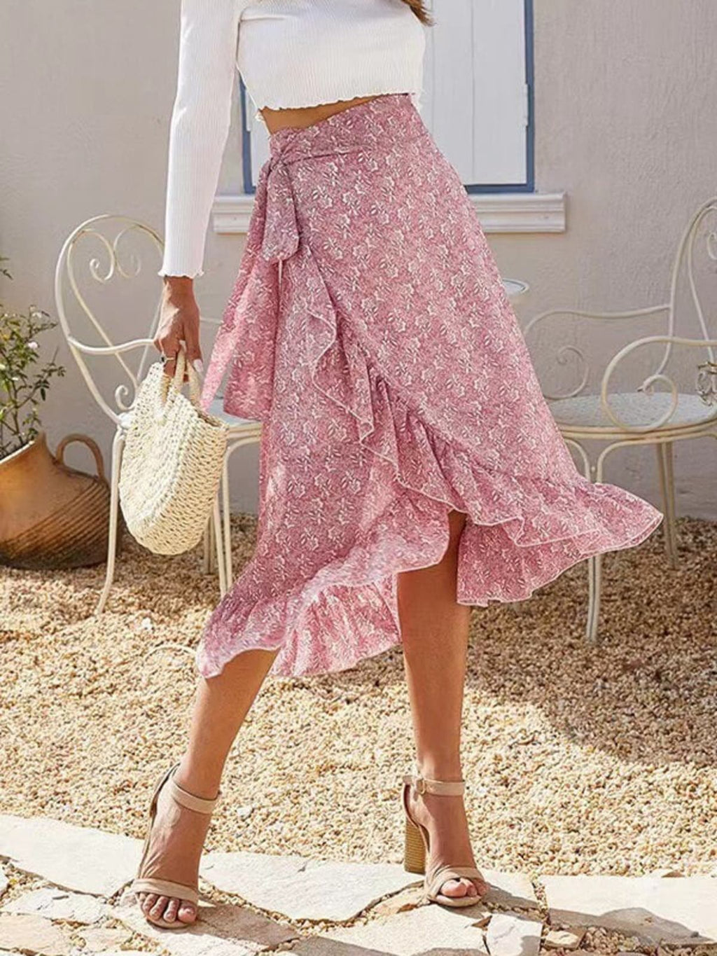 Woman wearing a floral wrap midi skirt with ruffles.