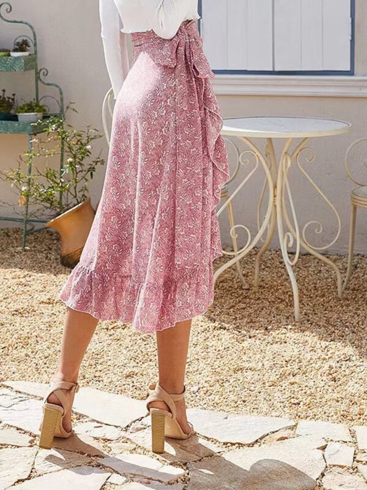 Woman wearing a floral wrap midi skirt with ruffles.