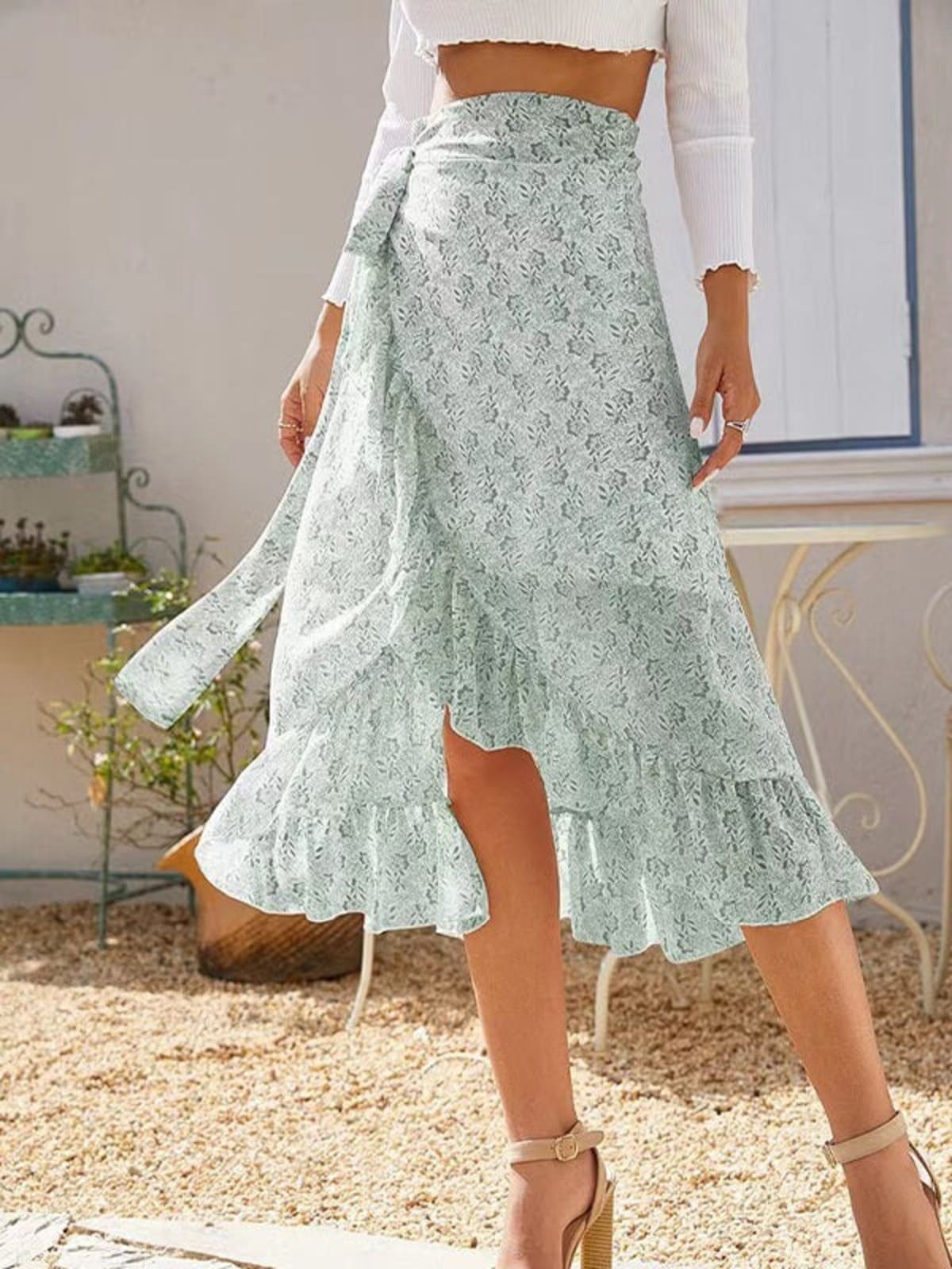 Woman wearing a floral wrap midi skirt with ruffles.