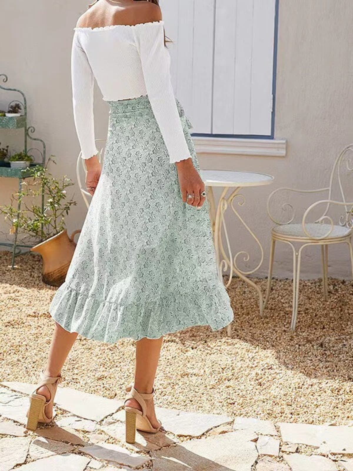 Woman wearing a floral wrap midi skirt with ruffles.
