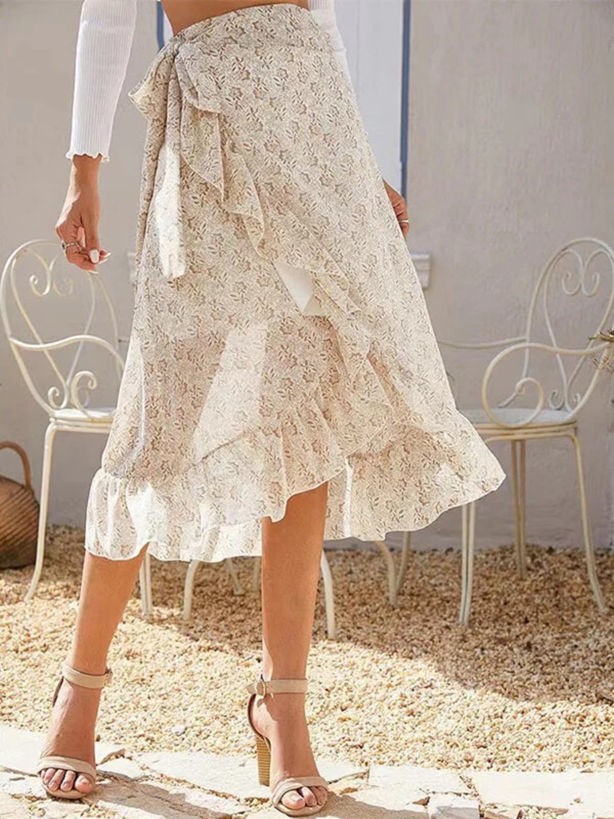 Woman wearing a floral wrap midi skirt with ruffles.