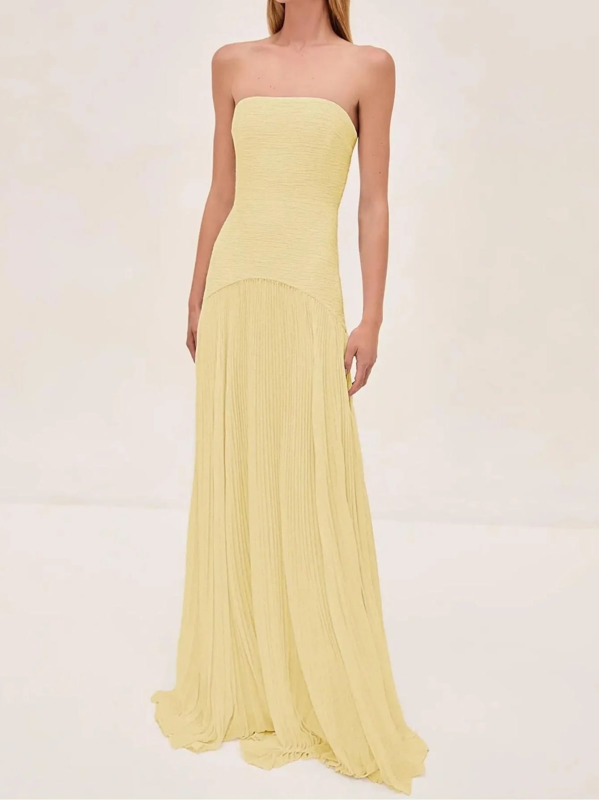 Strapless maxi dress with pleated skirt, worn at a formal event.