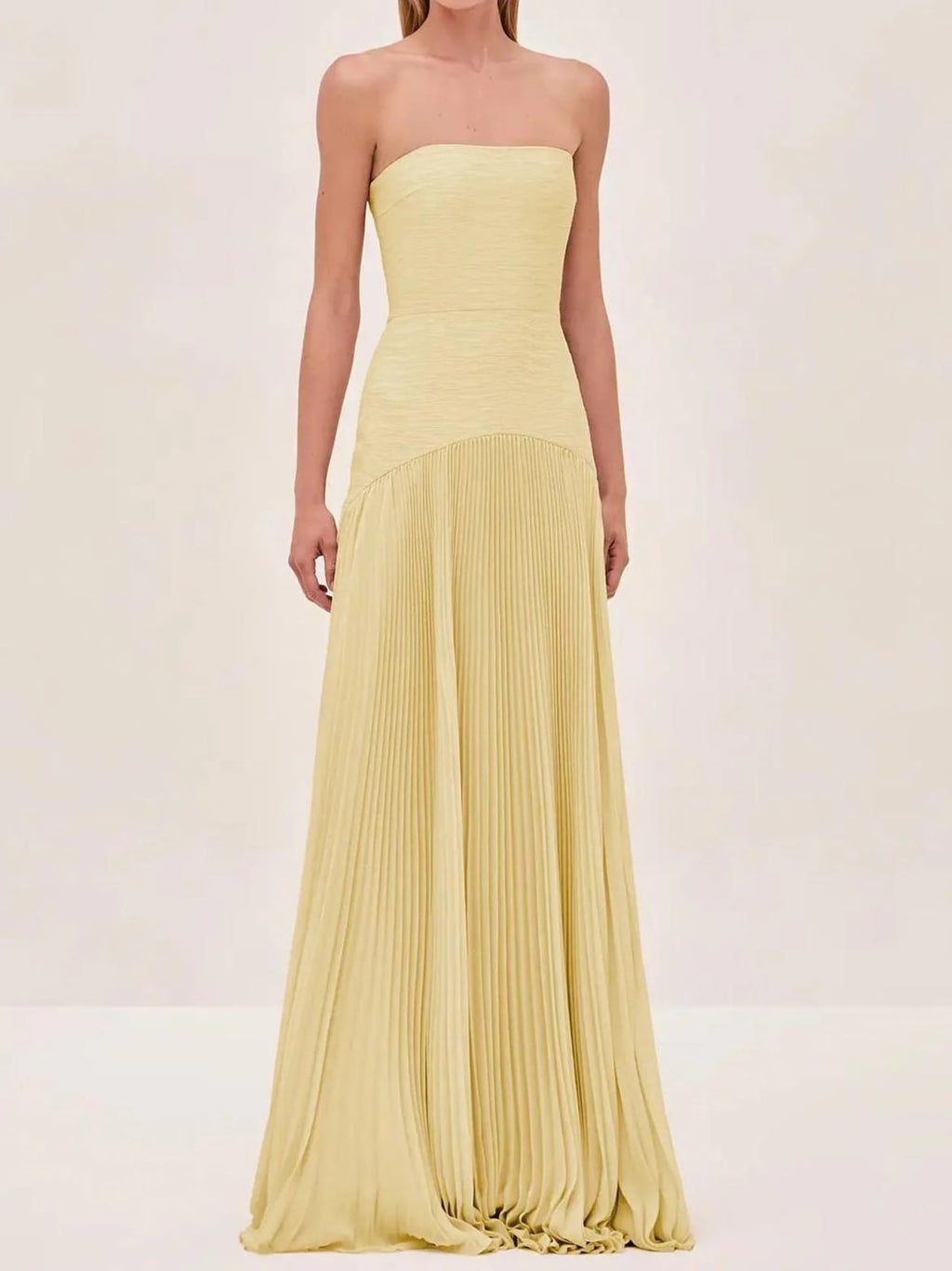Strapless maxi dress with pleated skirt, worn at a formal event.