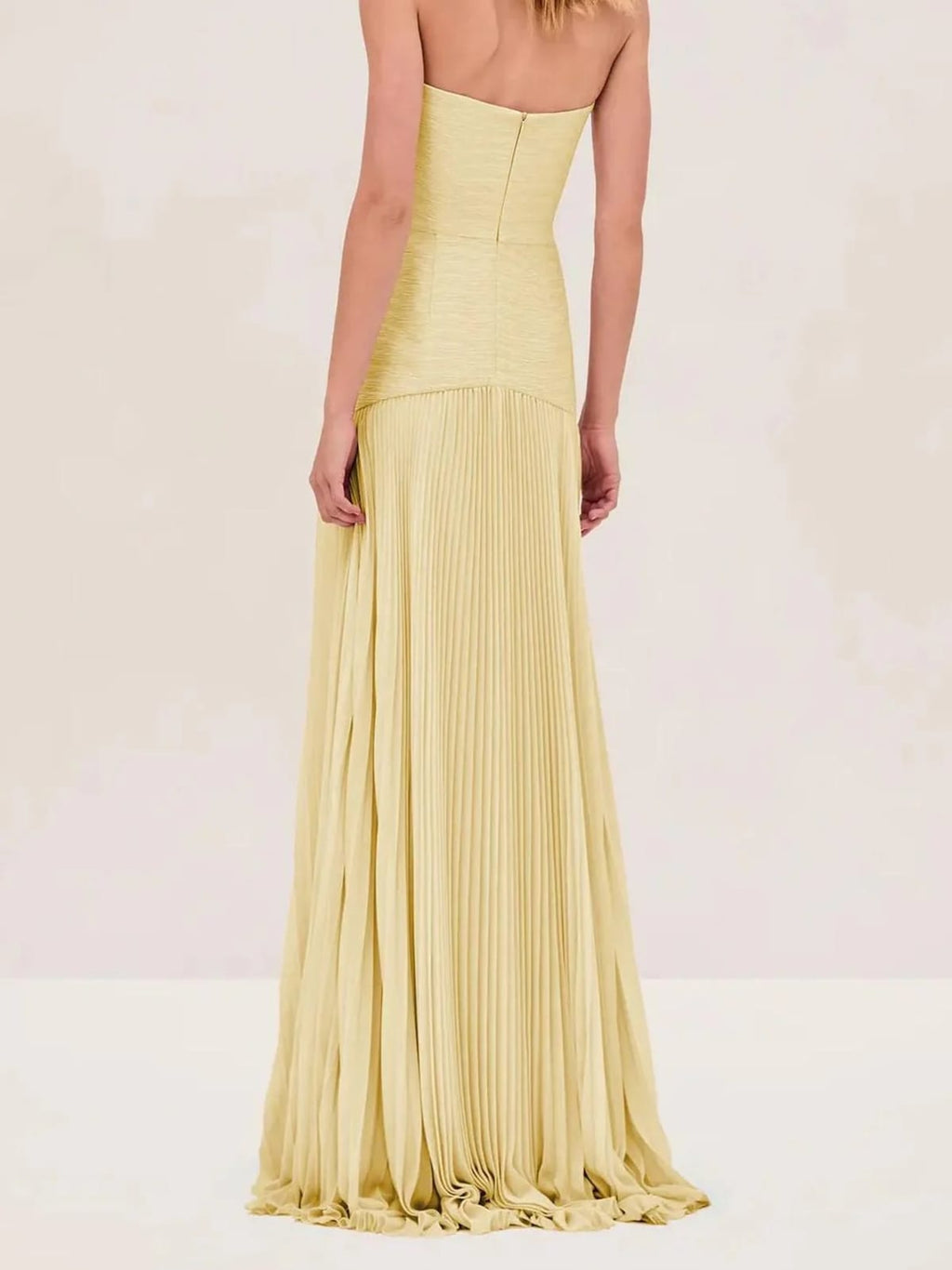 Strapless maxi dress with pleated skirt, worn at a formal event.
