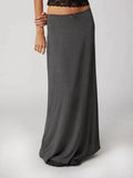 Model wearing a high-waisted flowy maxi skirt with a bow detail.