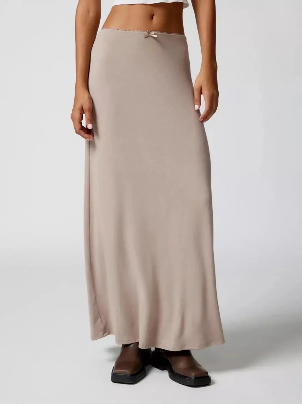Model wearing a high-waisted flowy maxi skirt with a bow detail.