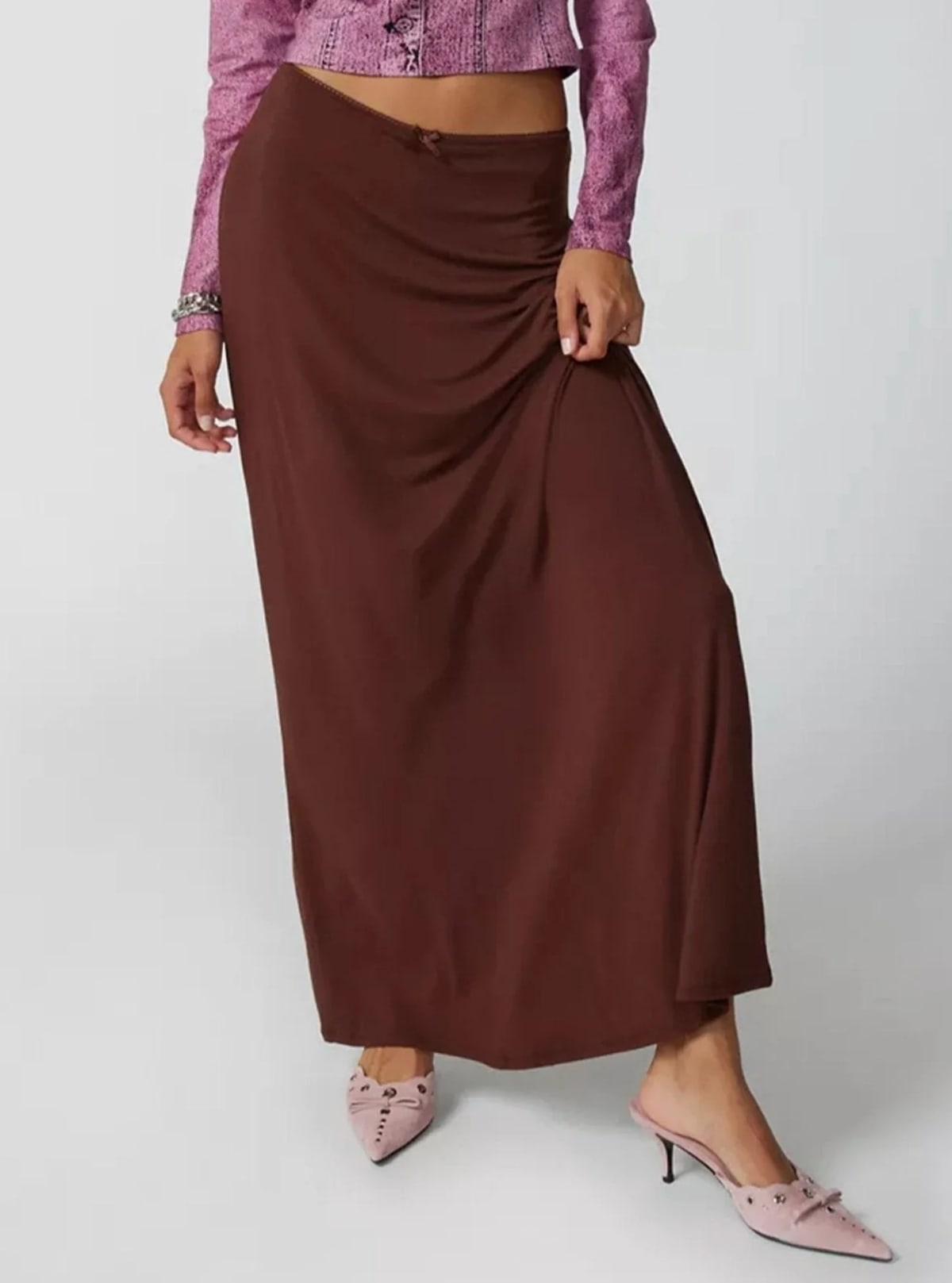 Model wearing a high-waisted flowy maxi skirt with a bow detail.