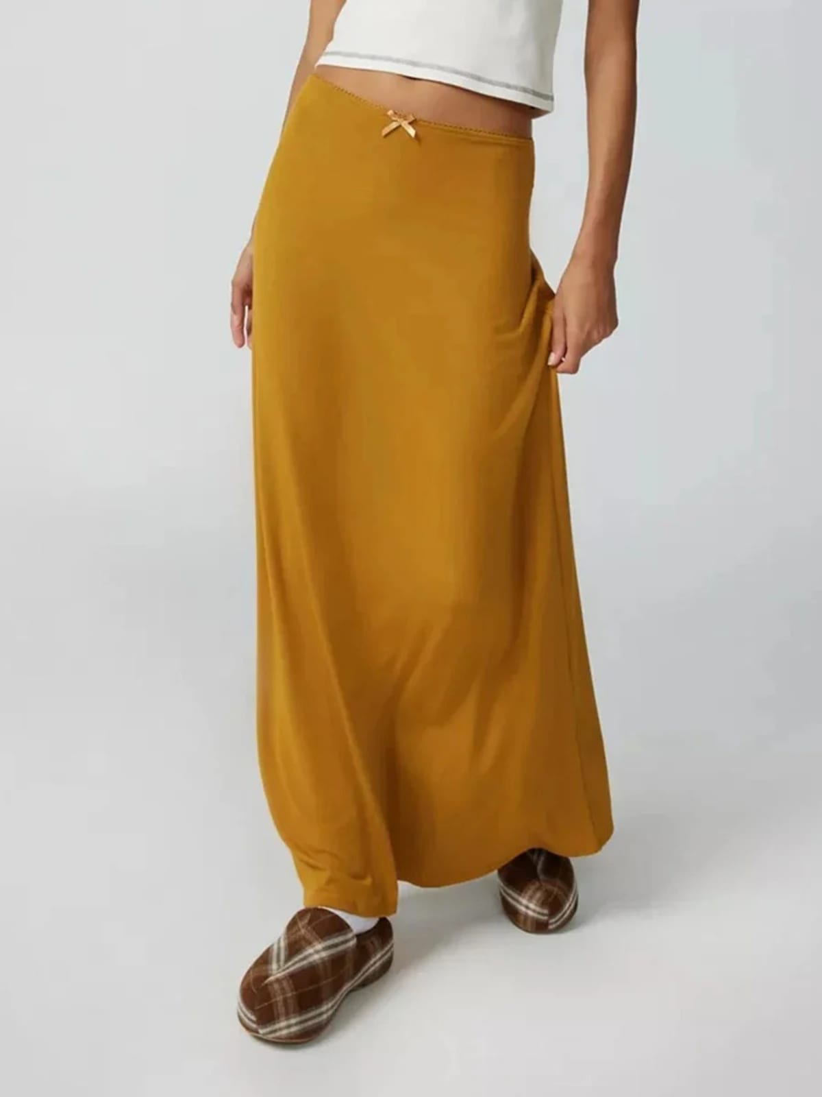 Model wearing a high-waisted flowy maxi skirt with a bow detail.