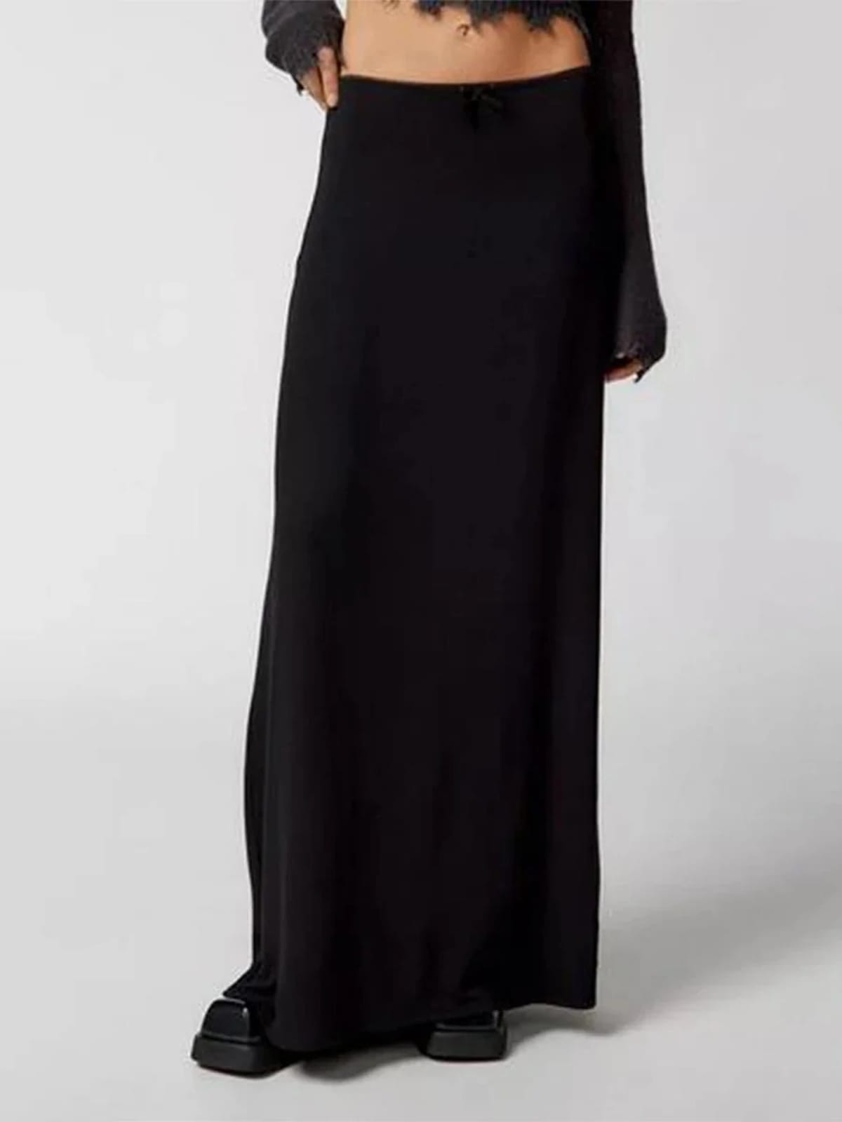 Model wearing a high-waisted flowy maxi skirt with a bow detail.