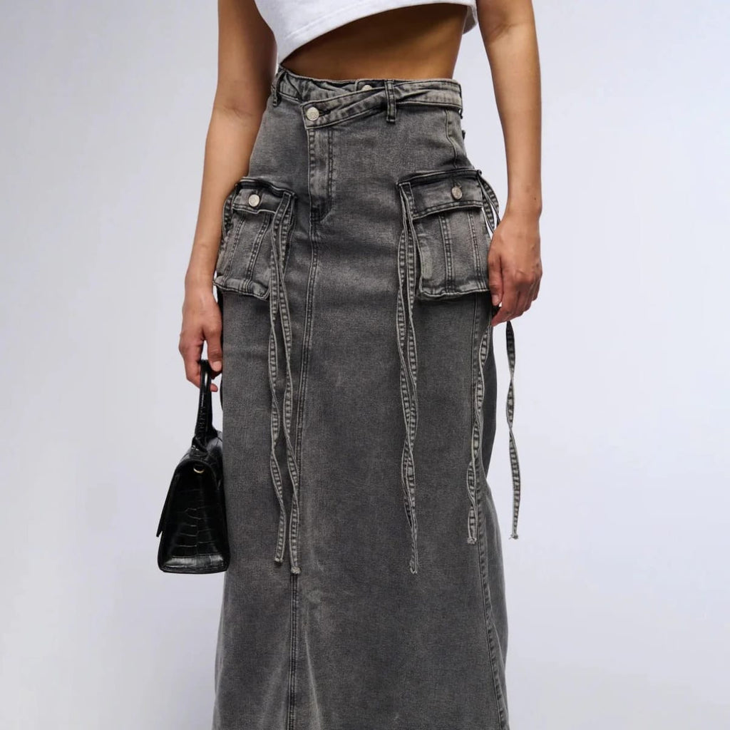 Maxi denim skirt with asymmetric waist, cargo pockets, decorative straps.