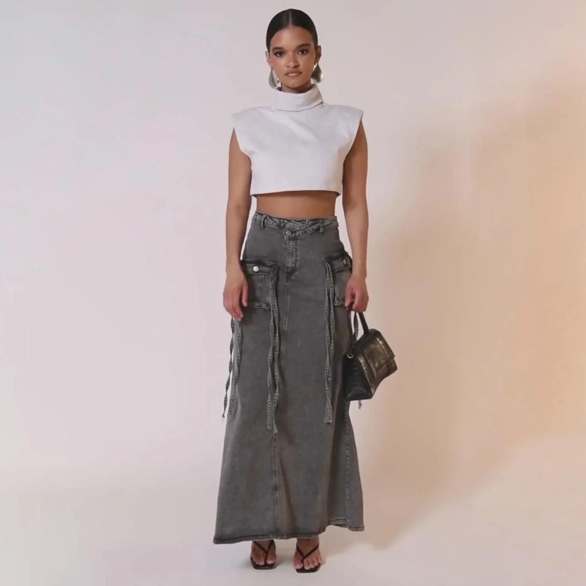 Maxi denim skirt with asymmetric waist, cargo pockets, decorative straps.