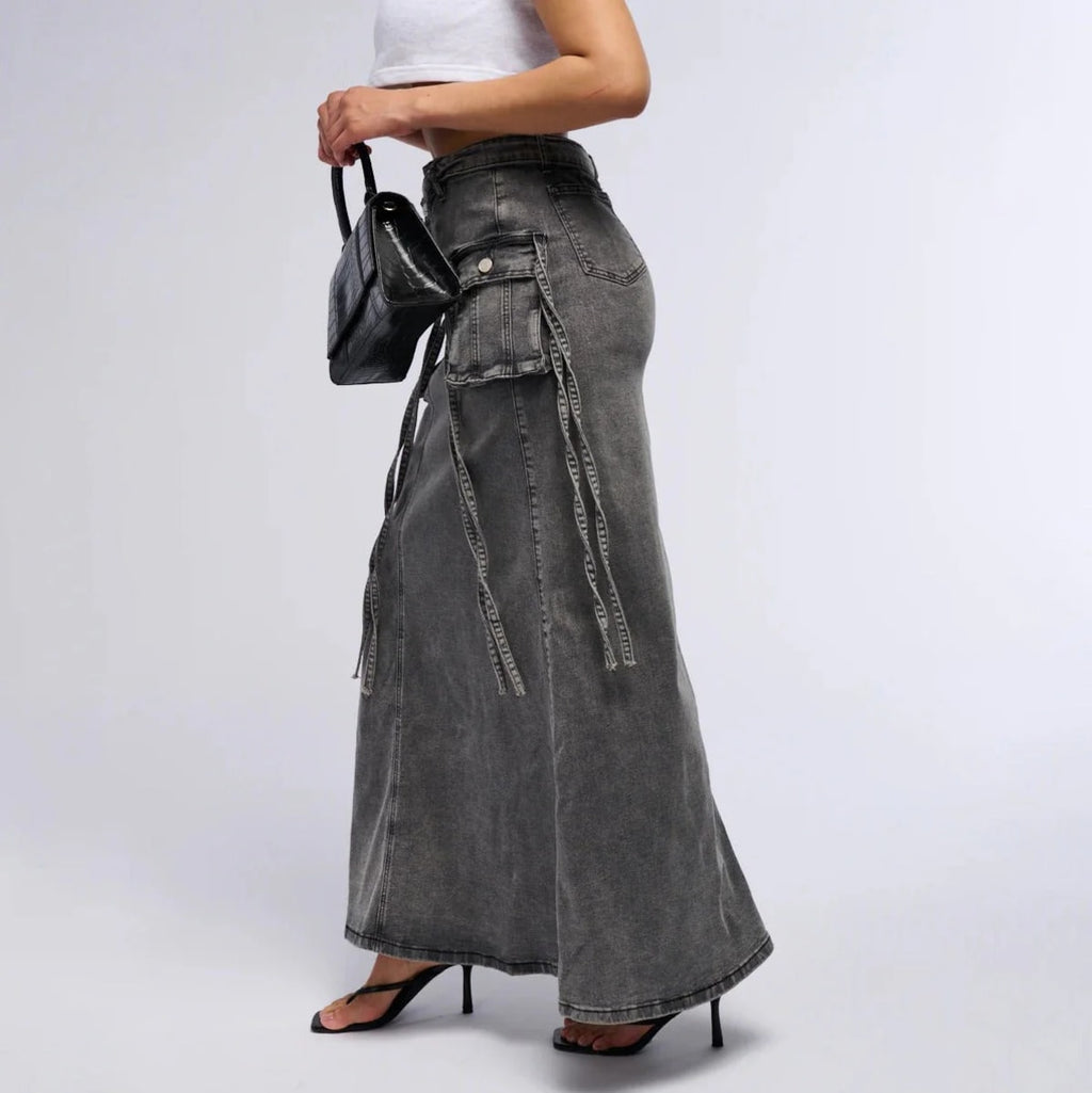 Maxi denim skirt with asymmetric waist, cargo pockets, decorative straps.