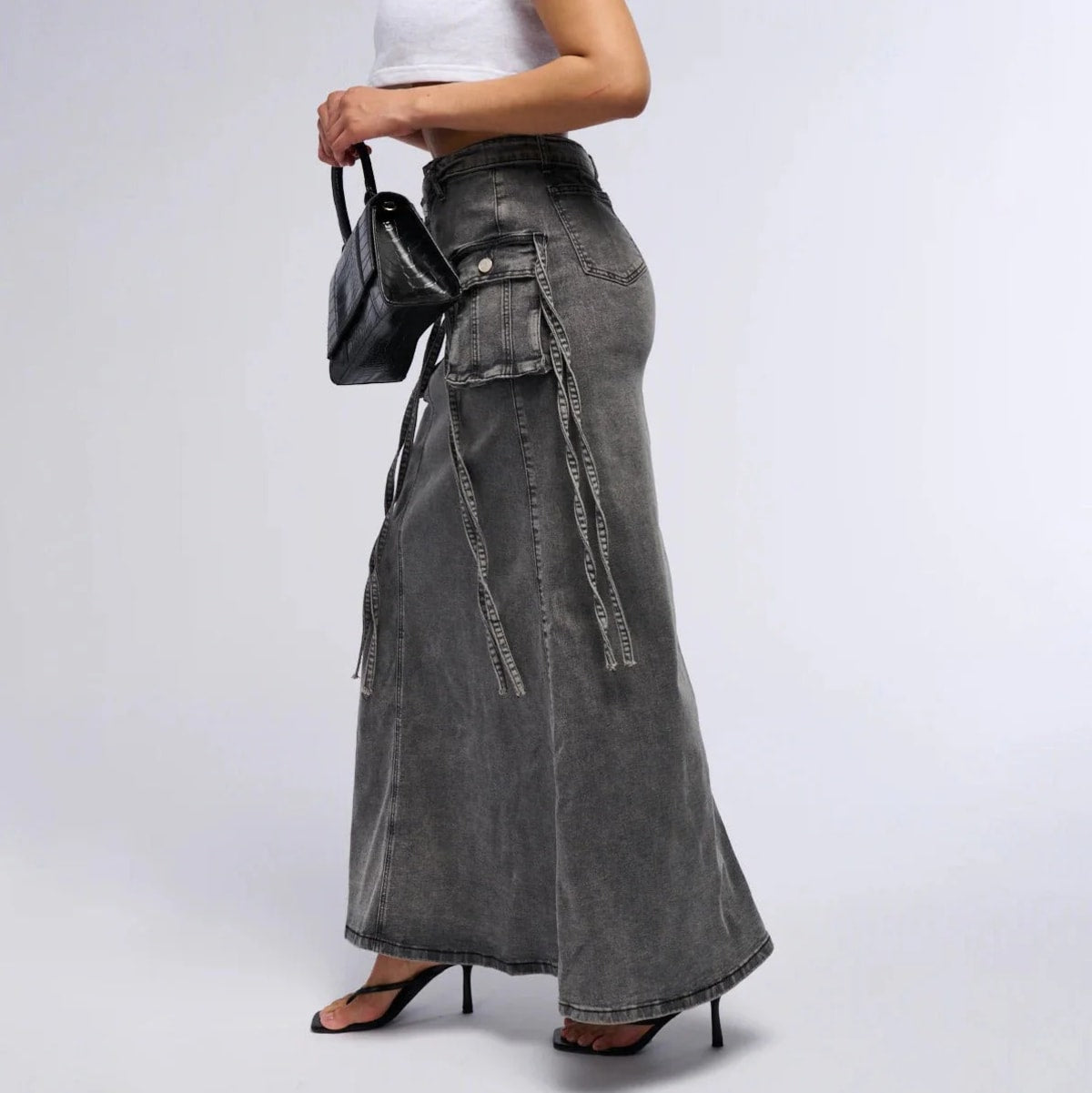 Maxi denim skirt with asymmetric waist, cargo pockets, decorative straps.