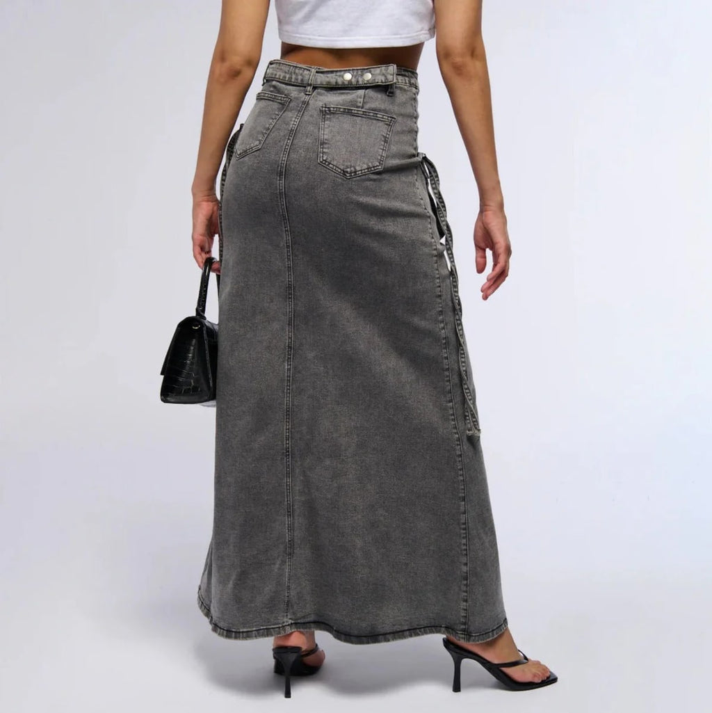 Maxi denim skirt with asymmetric waist, cargo pockets, decorative straps.