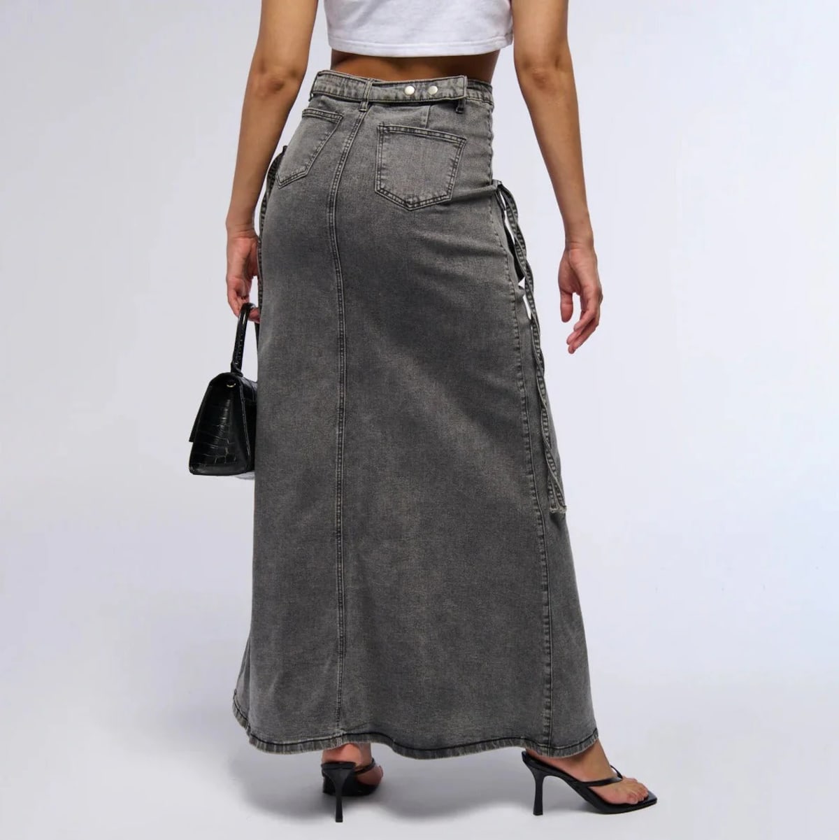 Maxi denim skirt with asymmetric waist, cargo pockets, decorative straps.