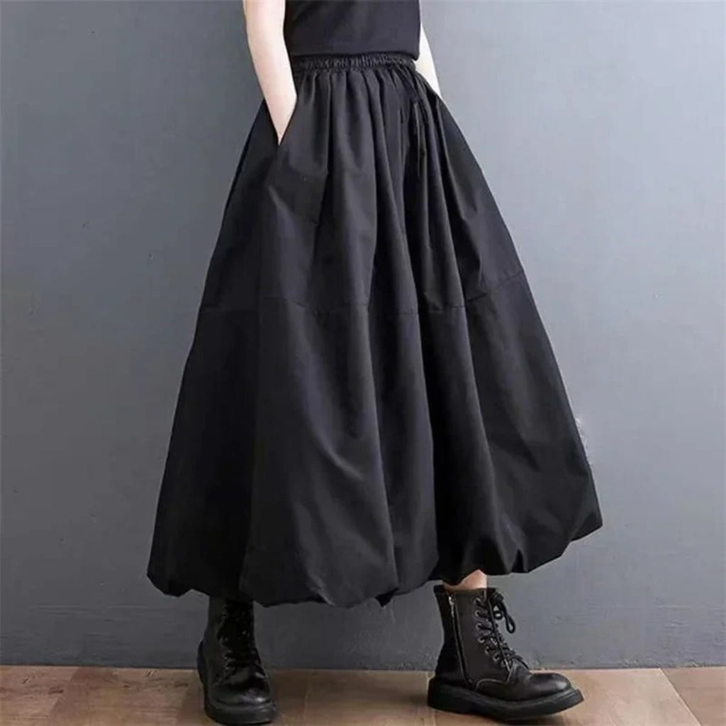 Woman wearing a voluminous black maxi skirt with elastic waist.