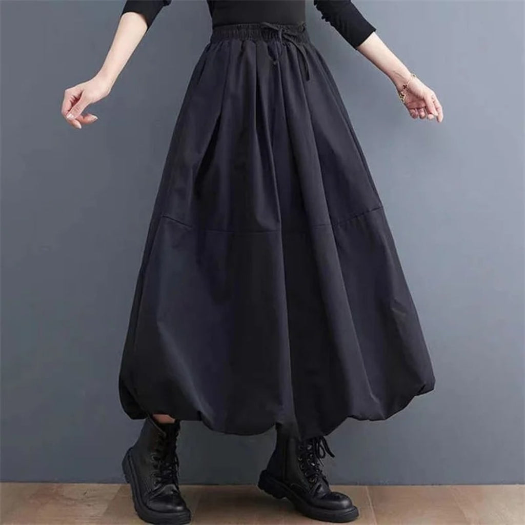 Woman wearing a voluminous black maxi skirt with elastic waist.