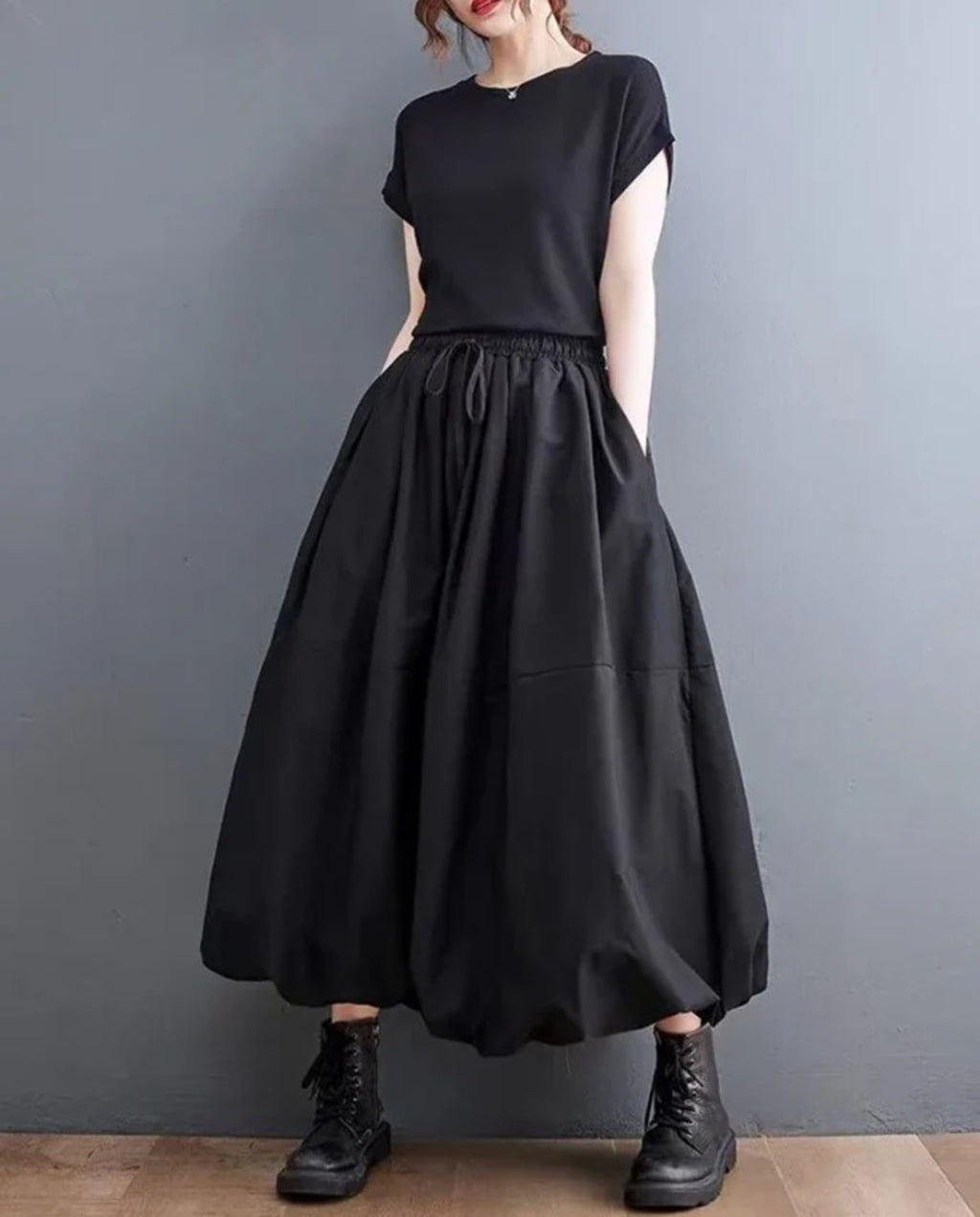 Woman wearing a voluminous black maxi skirt with elastic waist.