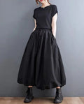 Woman wearing a voluminous black maxi skirt with elastic waist.