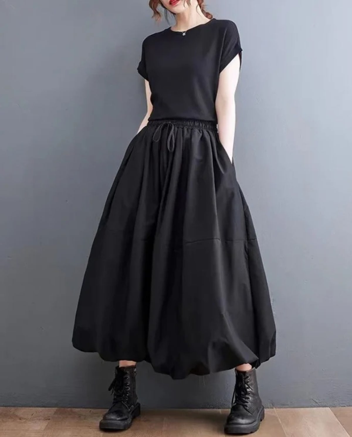 Woman wearing a voluminous black maxi skirt with elastic waist.