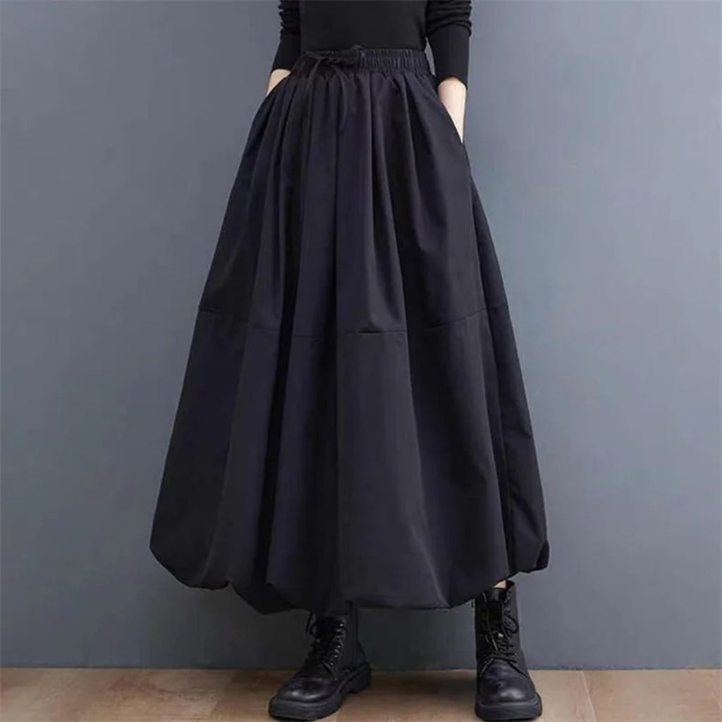 Woman wearing a voluminous black maxi skirt with elastic waist.