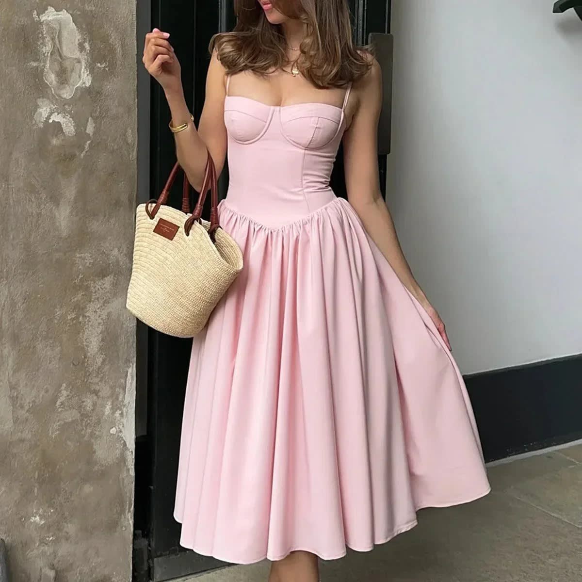 Woman wearing a bustier A-line midi dress with spaghetti straps.
